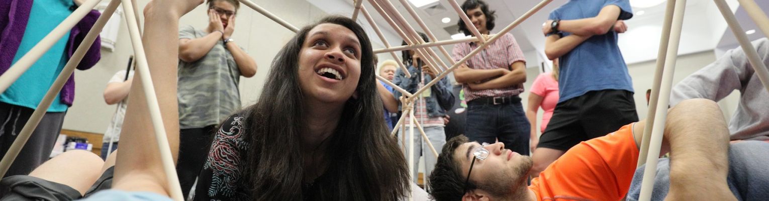 Students in our NFB EQ program smile from within a wooden structure they built.