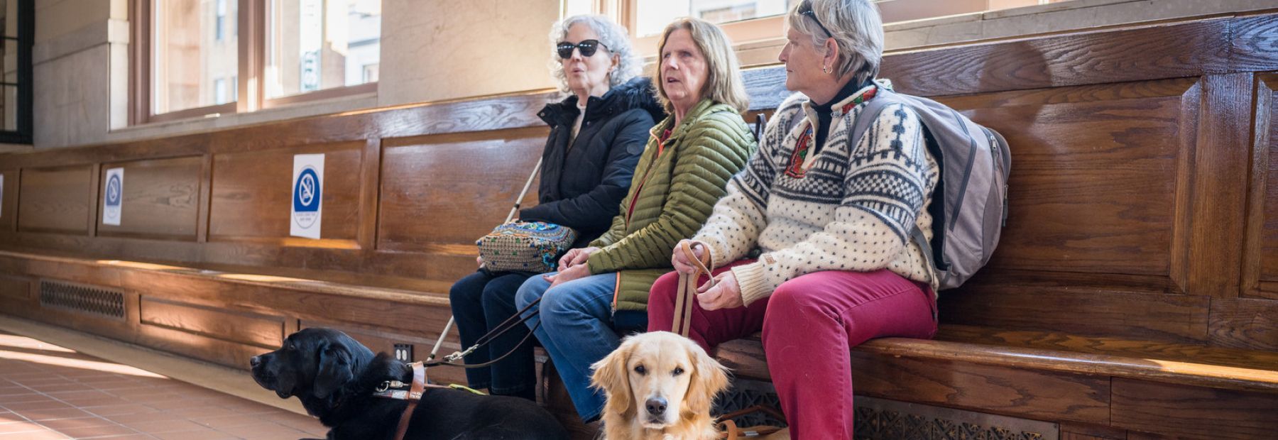 Three blind women talk at a train station.