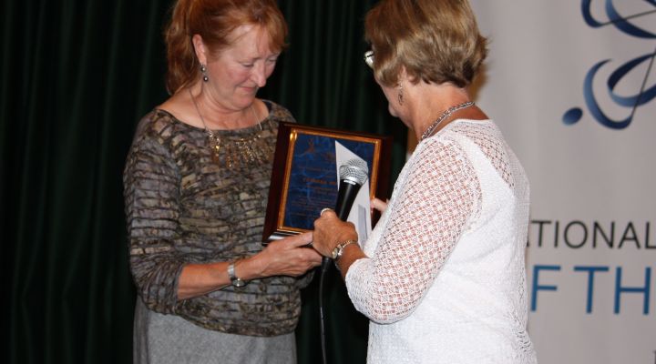 Theresa Postello is handed the Distinguished Educator of Blind Students Award