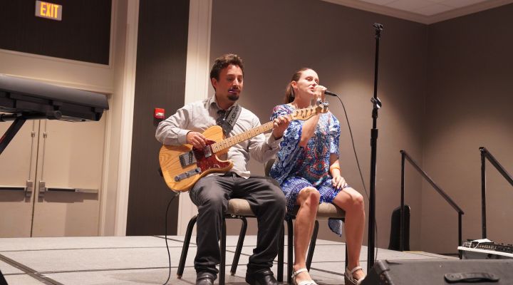 A guitarist and a singer perform a song during the annual talent show.