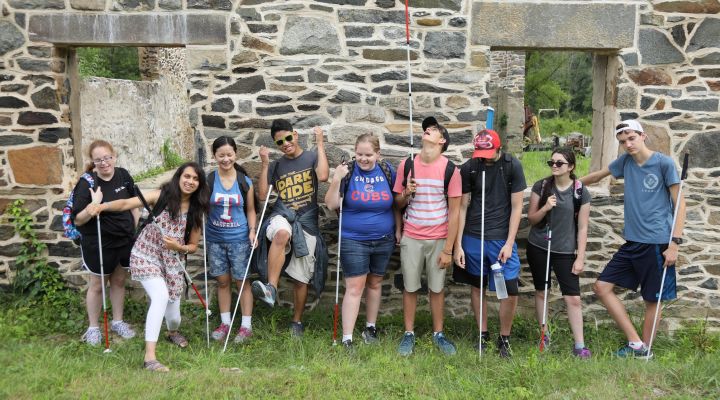 Students stand outside against a stone wall during the 2018 NFB EQ program.