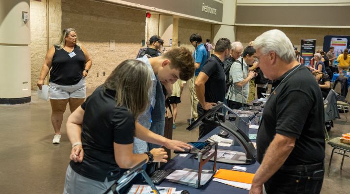 Two blind people test a new magnifier at an exhibit hall booth
