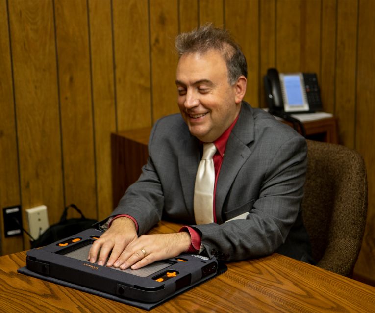 President Riccobono smiles and explores the Dynamic Tactile Device