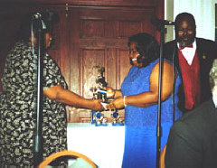 Shirley Barksdale, Treasurer of the Atlanta Chapter, presents the Member-of-the-Year award to Melissa Imtiaz at the chapter's first annual Black Tie-WShite Cane APpreciation Banquet while second vice president Keith Tonge looks on.