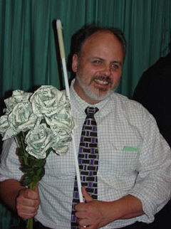 Dan Burke holds a bouquet of roses made of $5 bills that he won as a door prize at the banquet.