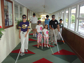 Sunday morning families were able to work with O and M teachers trained in the discovery method.  Here Wei Min Patrick and his family practice under sleepshades while Robert Scott instructs them in the use of the long white cane.