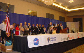 United States military veterans stand together on stage.  President Maurer is at the podium.