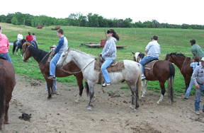 BLIND, Inc. students mount up in preparation for a trek on horseback. Those with some vision are wearing sleepshades.
