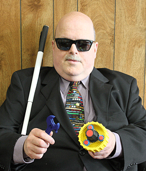 Robert Jaquiss holds gears made in a Stratasys 3D printer and a wrench created by the same machine.