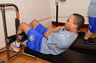 A young man does curls.