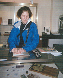 Debbie Stein touches and uses a slate used by Louis Braille