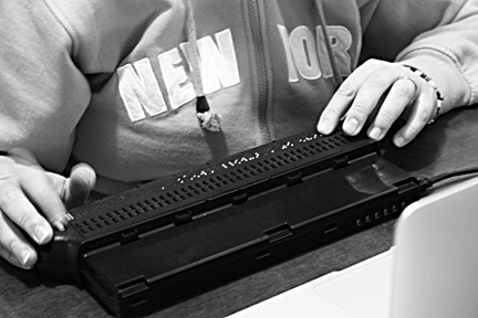Nihal Erkan reads Braille using a display connected to her iPhone.