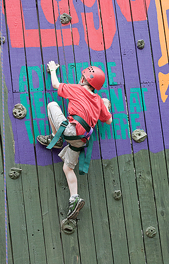 Neil Grunig scales a rock  wall.