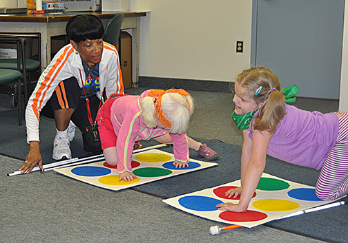 Denise, Chloe, and Devon play Twister.