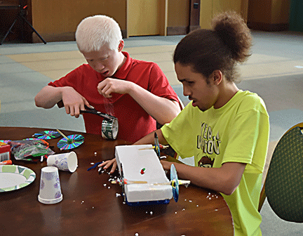 Elijah Anderson and Angel Ayala work together building their recycled racer.