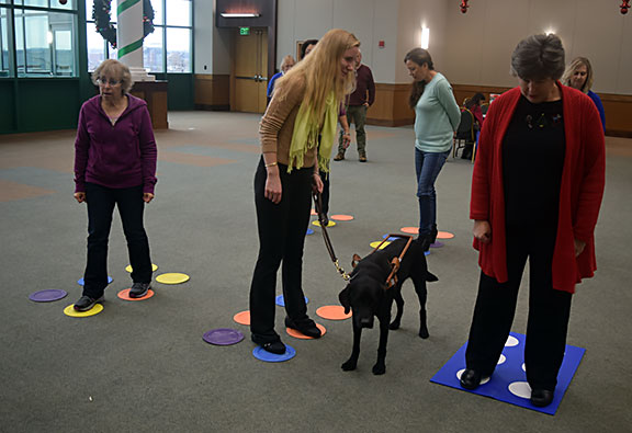 Tamala Young, Tammy Robar, and Lisa Craig participate in a make-and-take activity. They are creating a file folder game called &ldquo;mini Braille Twister&rdquo; by affixing chair leg cushions to file folders to create a large tactile Braille cell.