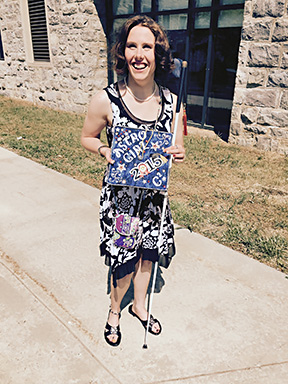Chelsea Cook holds her graduation cap to show the decorated top