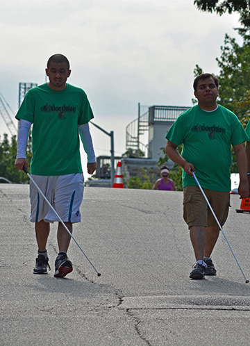 Jeremy Capati, an intern at the Jernigan Institute, and staff member Gabe Cazares walk with their canes.