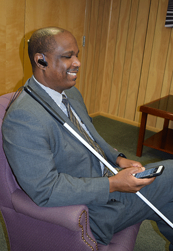 Anil Lewis listens to NFB-NEWSLINE on his iPhone using a Bluetooth earpiece 