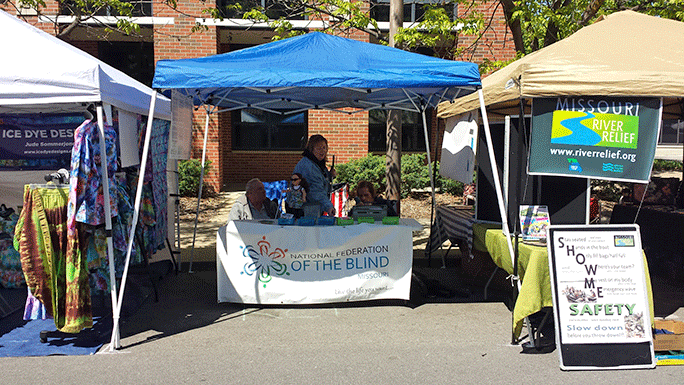 The National Federation of the Blind Columbia Chapter’s booth, situated between an organization dedicated to cleaning trash from the Missouri River and a woman selling tie-dye clothing.