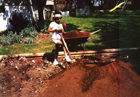 This blind youngster prepares a garden bed for planting vegetables.