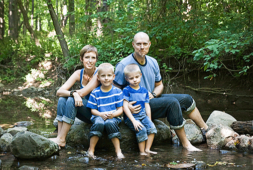 The Vescelus family sitting on some rocks in the creek
