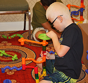 Boy builds a tower with interlocking puzzle pieces
