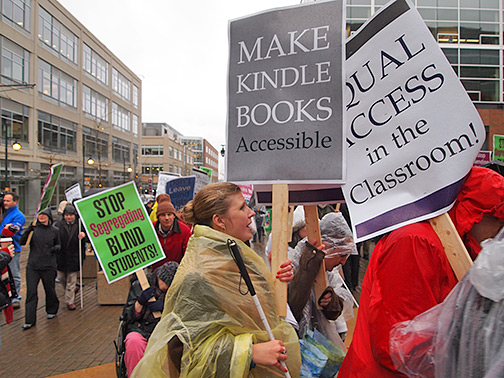 Federationists carrying placards demonstrate in front of Amazon headquarters on a rainy Seattle morning