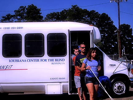 Three students from the Louisiana Center for the Blind step off the bus and head toward the playing field.