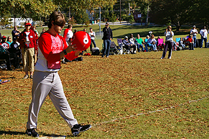 A boy stands poised to throw and kick a ball.