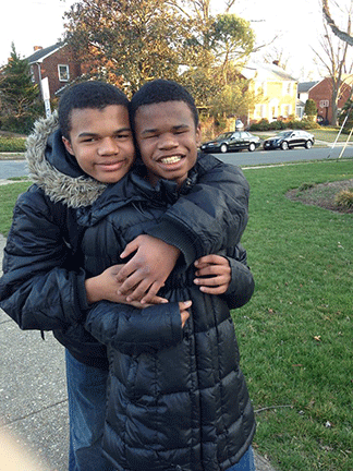 Brothers Andre and Joseph Shariff stand together outdoors.
