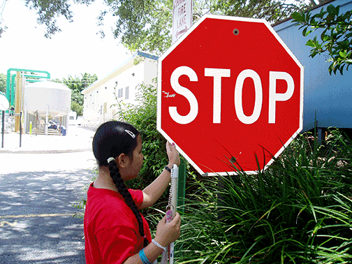 Ashleah Chamberlain examines a stop sign.