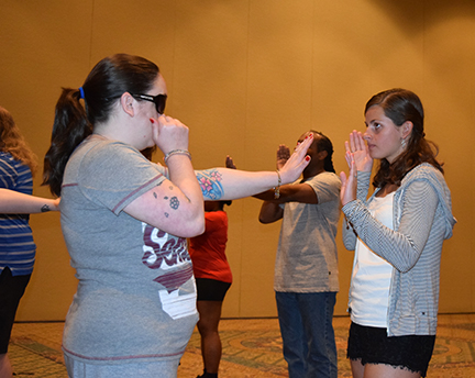 Two girls practice moves in a self-defense workshop.