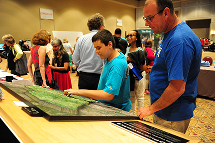 A boy and his father examine a relief map.