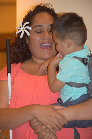 A mother holds her young son and talks to him.